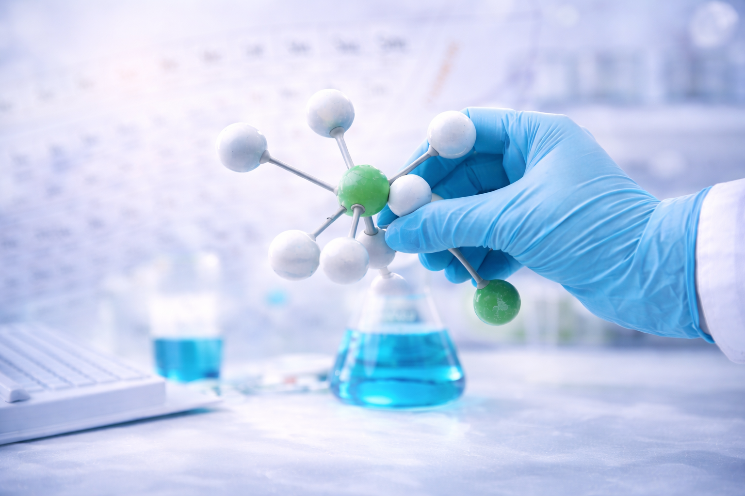 Pharmaceutical research scientist examining a molecular structure model in a modern laboratory environment